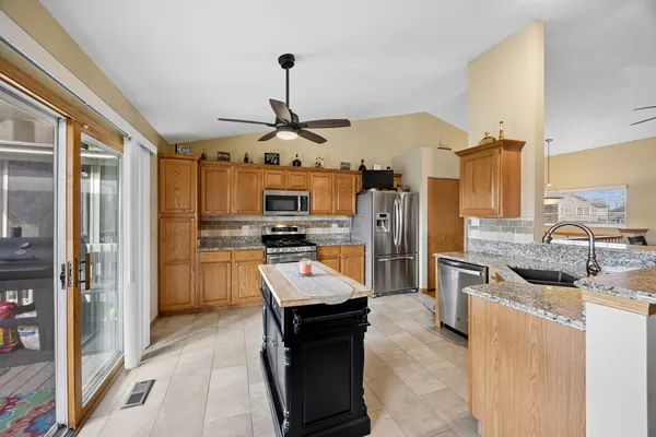 a kitchen with stainless steel appliances granite countertop a sink a stove and a refrigerator