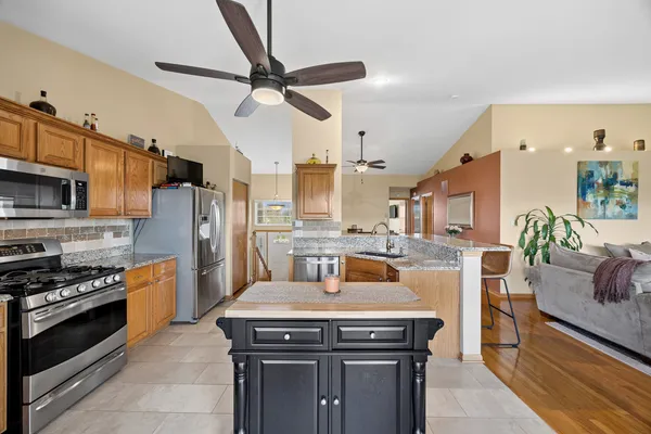a kitchen with stainless steel appliances granite countertop a stove a refrigerator and a sink