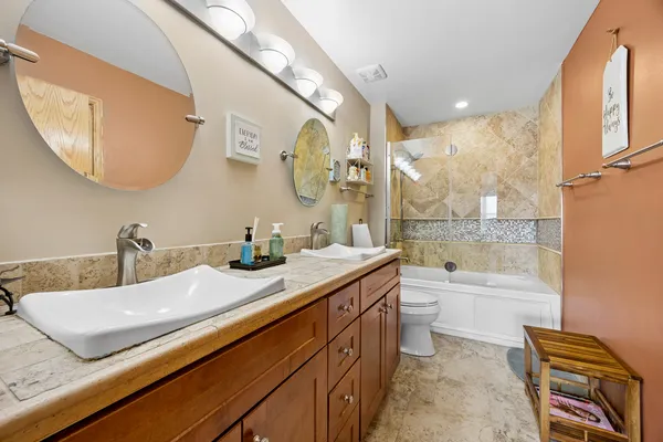 a bathroom with a granite countertop sink a toilet and bathtub