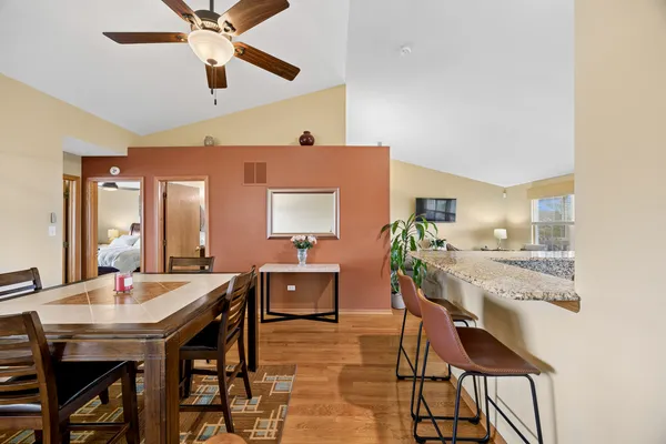 a view of a dining room with furniture and a chandelier fan