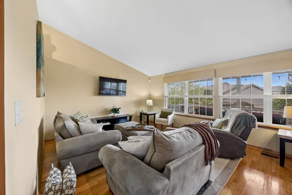a living room with furniture large windows and a flat screen tv