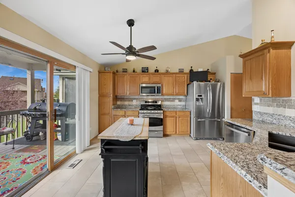 a kitchen with stainless steel appliances granite countertop a refrigerator a stove and a sink