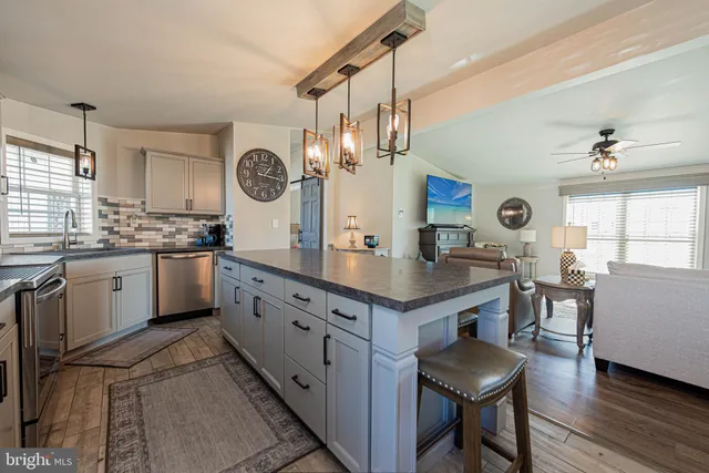 a kitchen with granite countertop a stove a sink a dining table and chairs