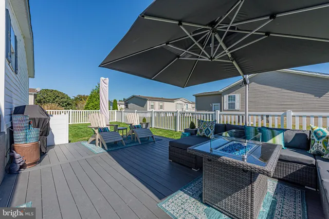 a view of a roof deck with table and chairs couches under an umbrella