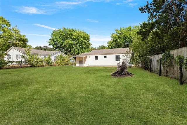 a backyard of a house with plants and large trees