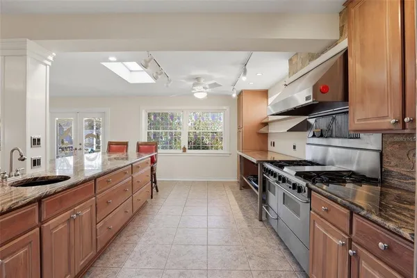 a kitchen with stainless steel appliances granite countertop a stove a sink and a microwave