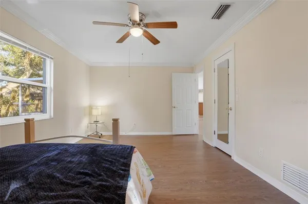 a bedroom with a bed ceiling fan and a window