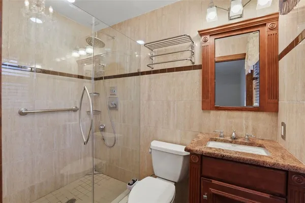 a bathroom with a granite countertop sink toilet a mirror and shower