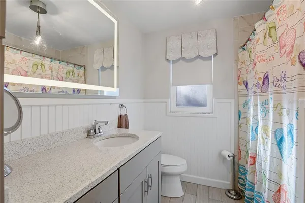 a bathroom with a sink a toilet and a mirror