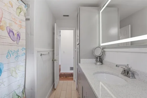a bathroom with a tub sink and mirror