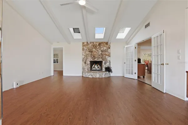 a view of a livingroom with wooden floor a fireplace and window