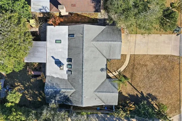 an aerial view of a house with swimming pool and large trees