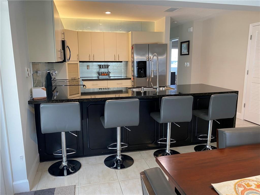 1978 Park Place Boca Raton, FL 33486 - Photo 19 of 34 a kitchen with a dining table chairs sink and view living room