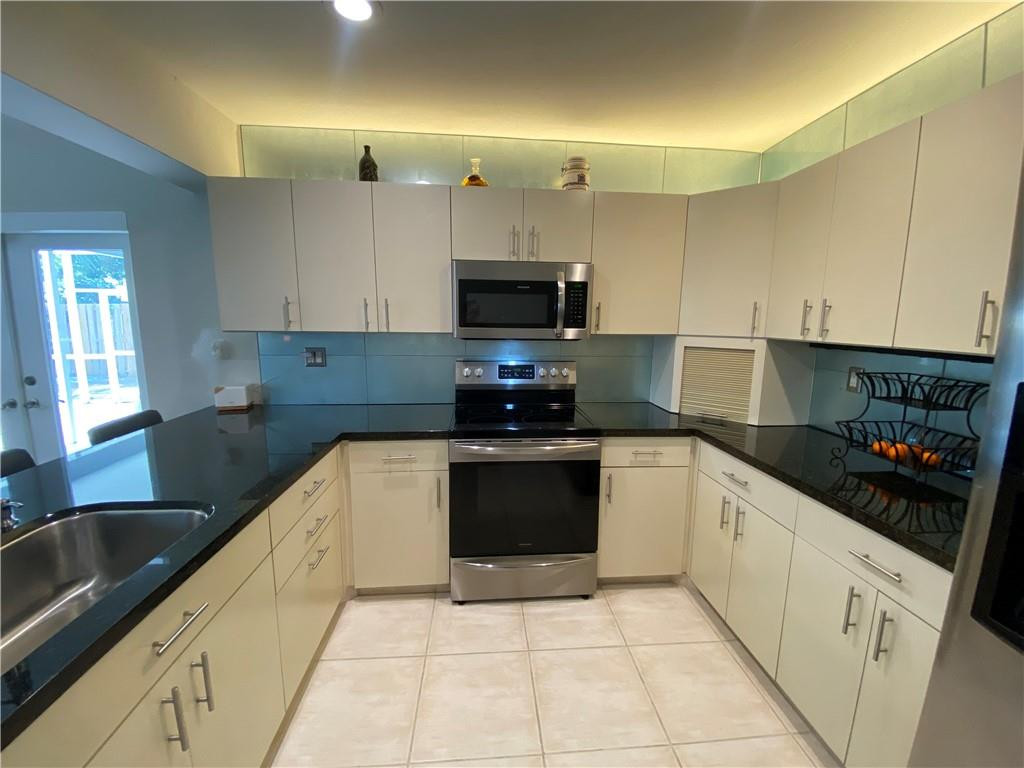1978 Park Place Boca Raton, FL 33486 - Photo 21 of 34 a kitchen with granite countertop a sink a stove and cabinets