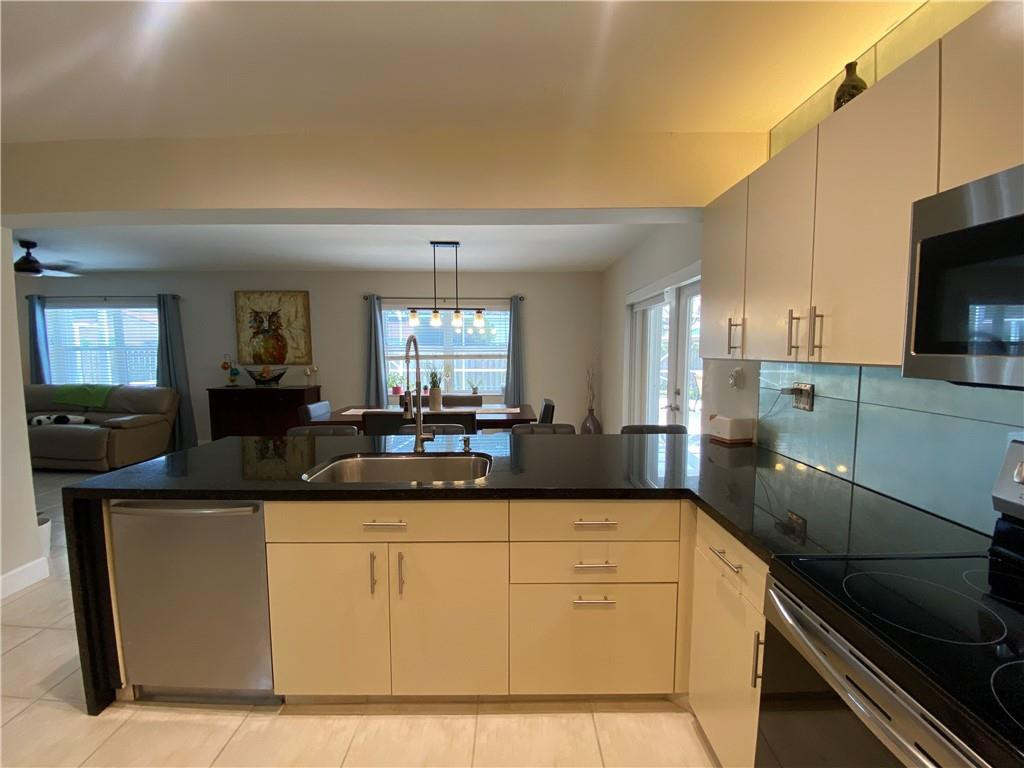 1978 Park Place Boca Raton, FL 33486 - Photo 22 of 34 a kitchen with stainless steel appliances granite countertop a sink and a stove