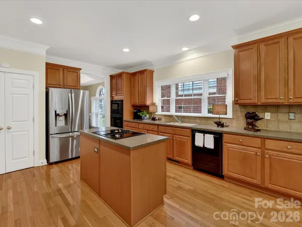 a kitchen with stainless steel appliances granite countertop a stove a sink dishwasher a refrigerator and a oven