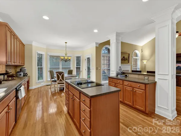 a kitchen with stainless steel appliances granite countertop a stove a sink dishwasher and a refrigerator with wooden floor