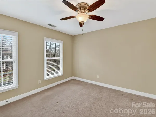 an empty room with closet and ceiling fan
