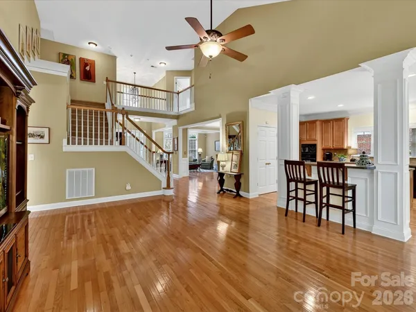 a view of a livingroom with furniture a ceiling fan and wooden floor