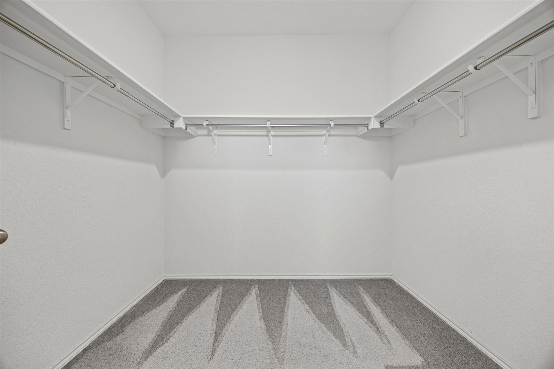 2471 Sunrise Road, Unit 64 Round Rock, TX 78664 - Photo 14 of 32 Ample shelving and hanging rods provide extensive storage in this carpeted walk-in closet.