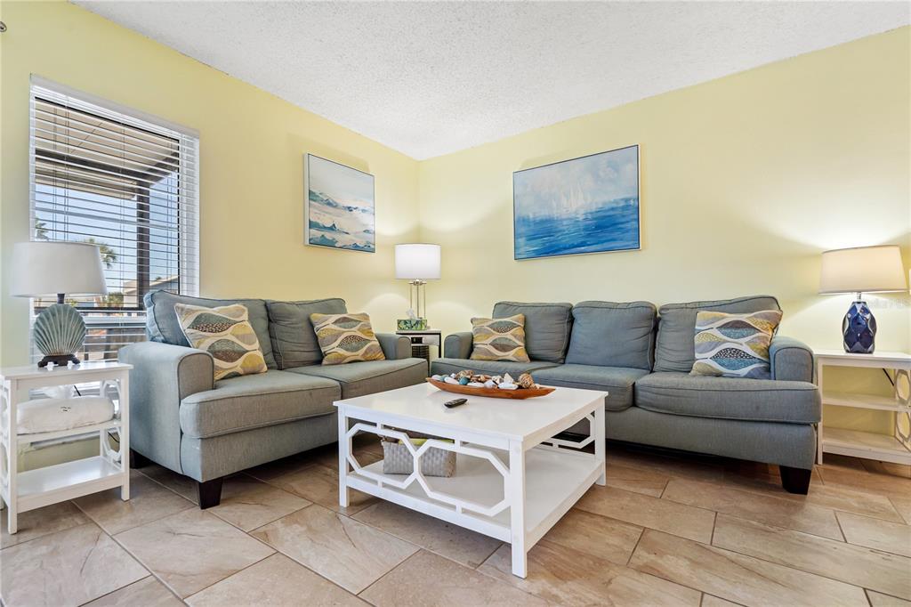 230 Medallion Boulevard, Unit E Madeira Beach, FL 33708 - Photo 4 of 35 a living room with furniture and a couch