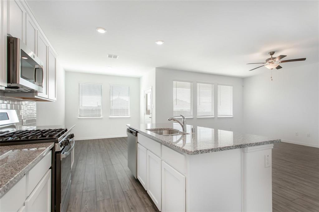 2157 Clarion Drive Forney, TX 75126 - Photo 15 of 28 a kitchen with granite countertop cabinets a sink a window and stainless steel appliances