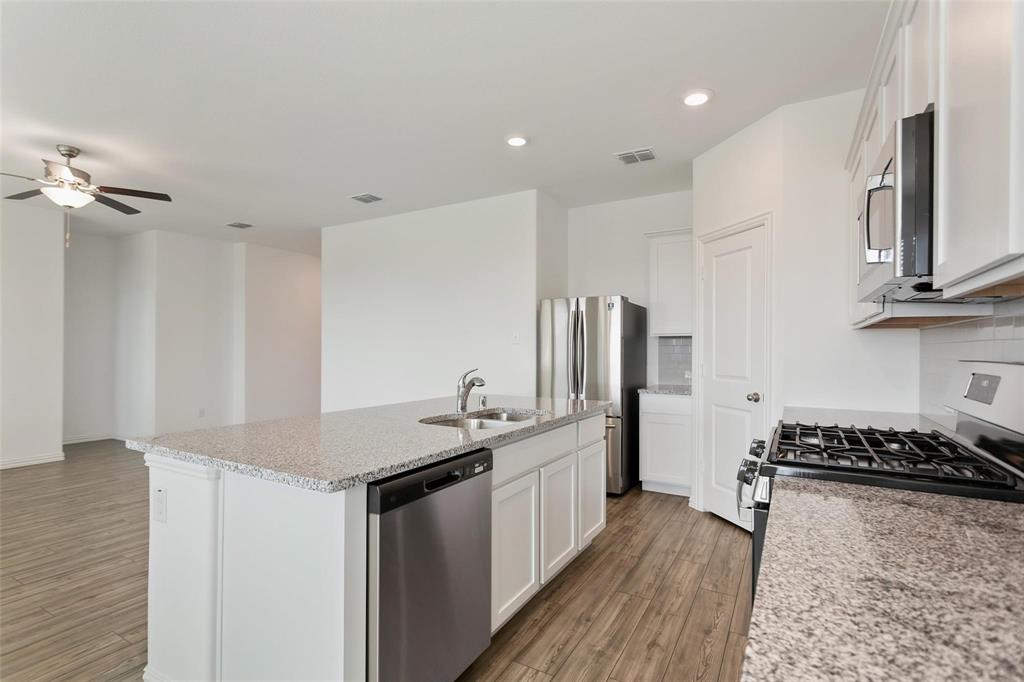 2157 Clarion Drive Forney, TX 75126 - Photo 18 of 28 a kitchen with stainless steel appliances granite countertop a sink stove and refrigerator