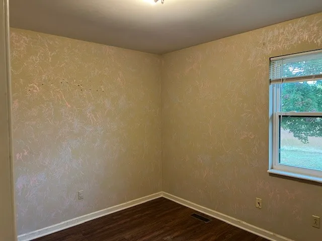 a view of a small space with wooden floor and a window