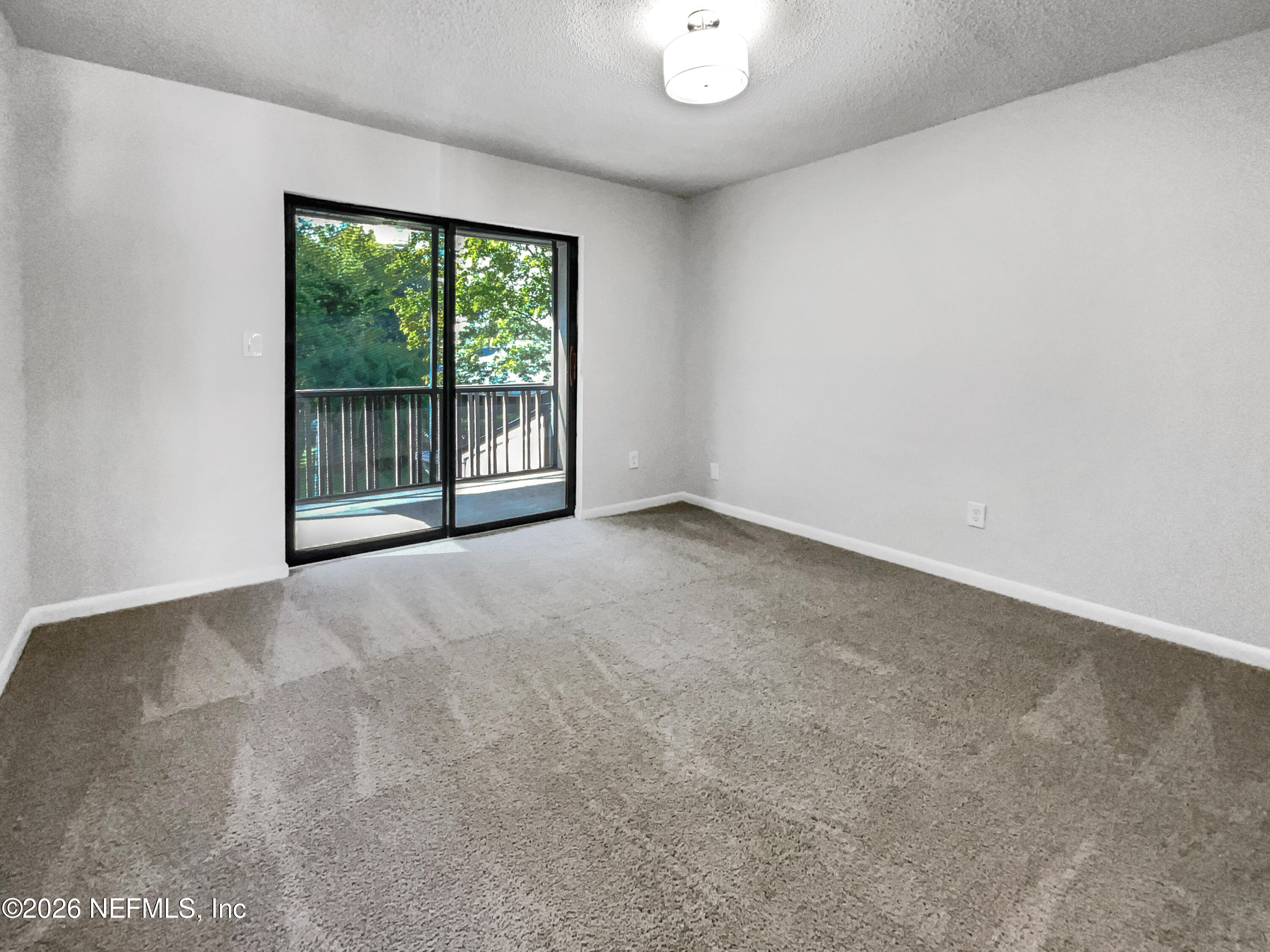 7208 Cypress Cove Road, Unit 13 Jacksonville, FL 32244 - Photo 12 of 22 an empty room with large windows