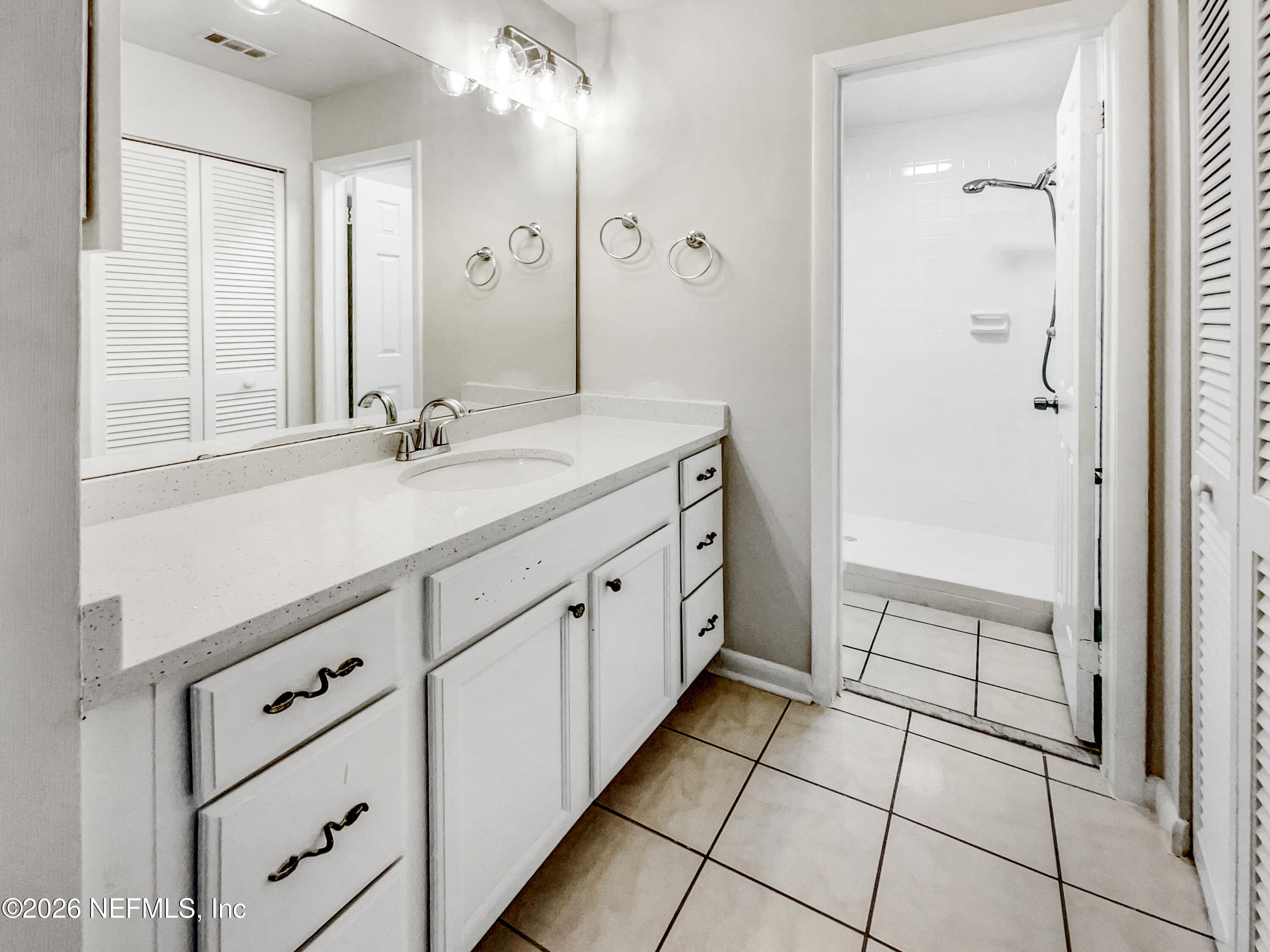 7208 Cypress Cove Road, Unit 13 Jacksonville, FL 32244 - Photo 15 of 22 a spacious bathroom with a double vanity sink a mirror and a shower