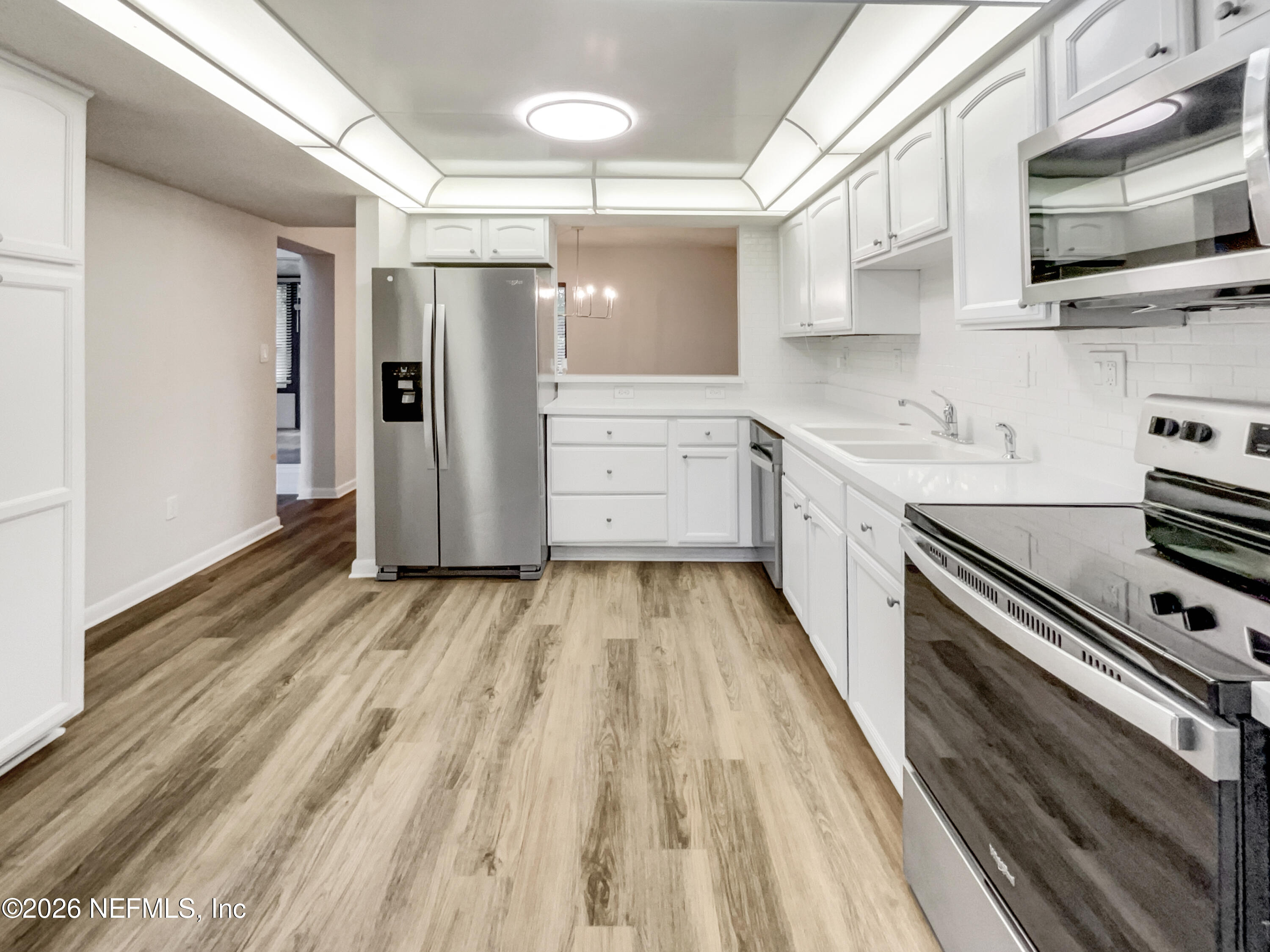 7208 Cypress Cove Road, Unit 13 Jacksonville, FL 32244 - Photo 5 of 22 a kitchen with white cabinets and appliances