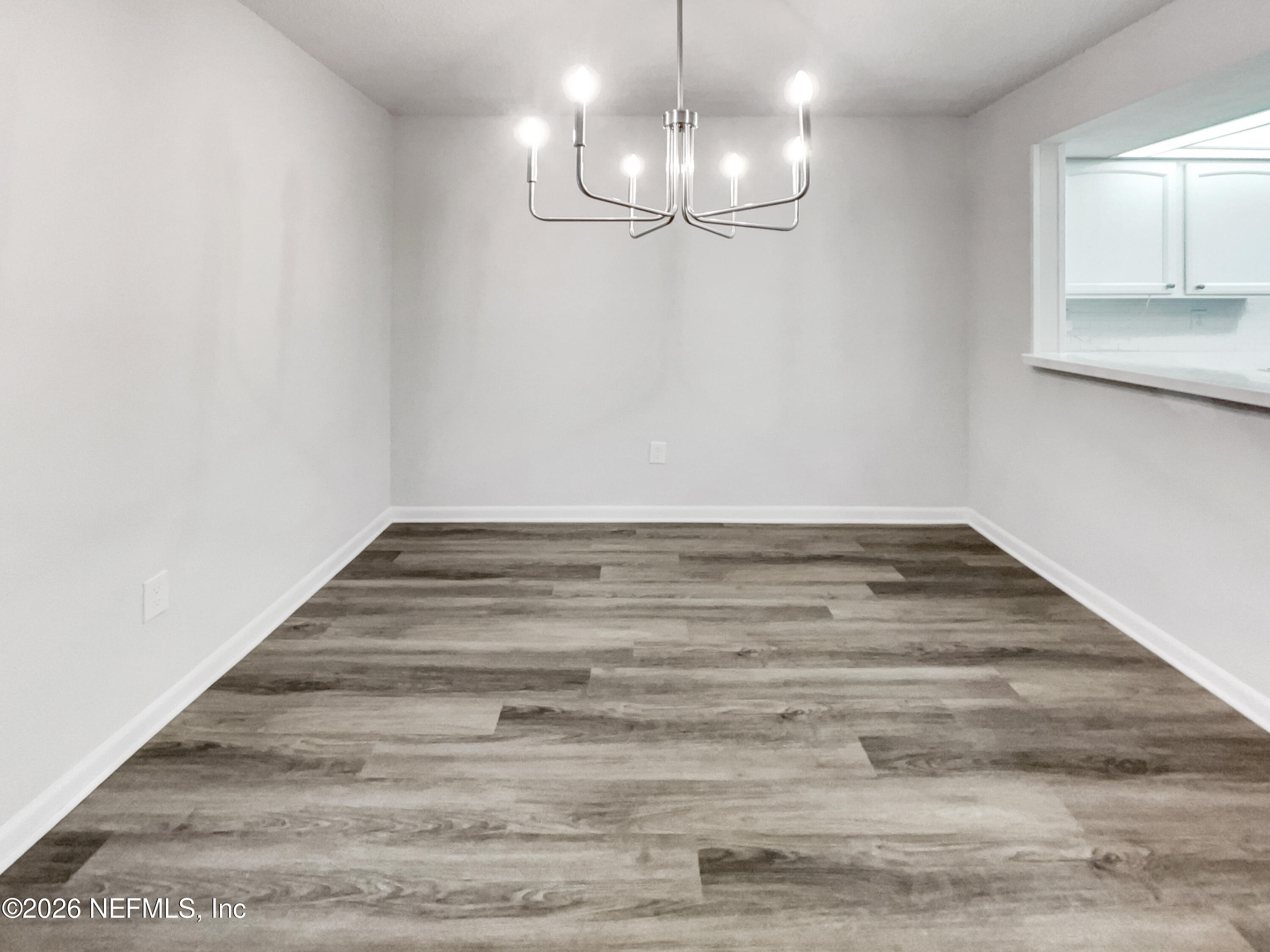 7208 Cypress Cove Road, Unit 13 Jacksonville, FL 32244 - Photo 7 of 22 a view of a room with wooden floor and chandelier