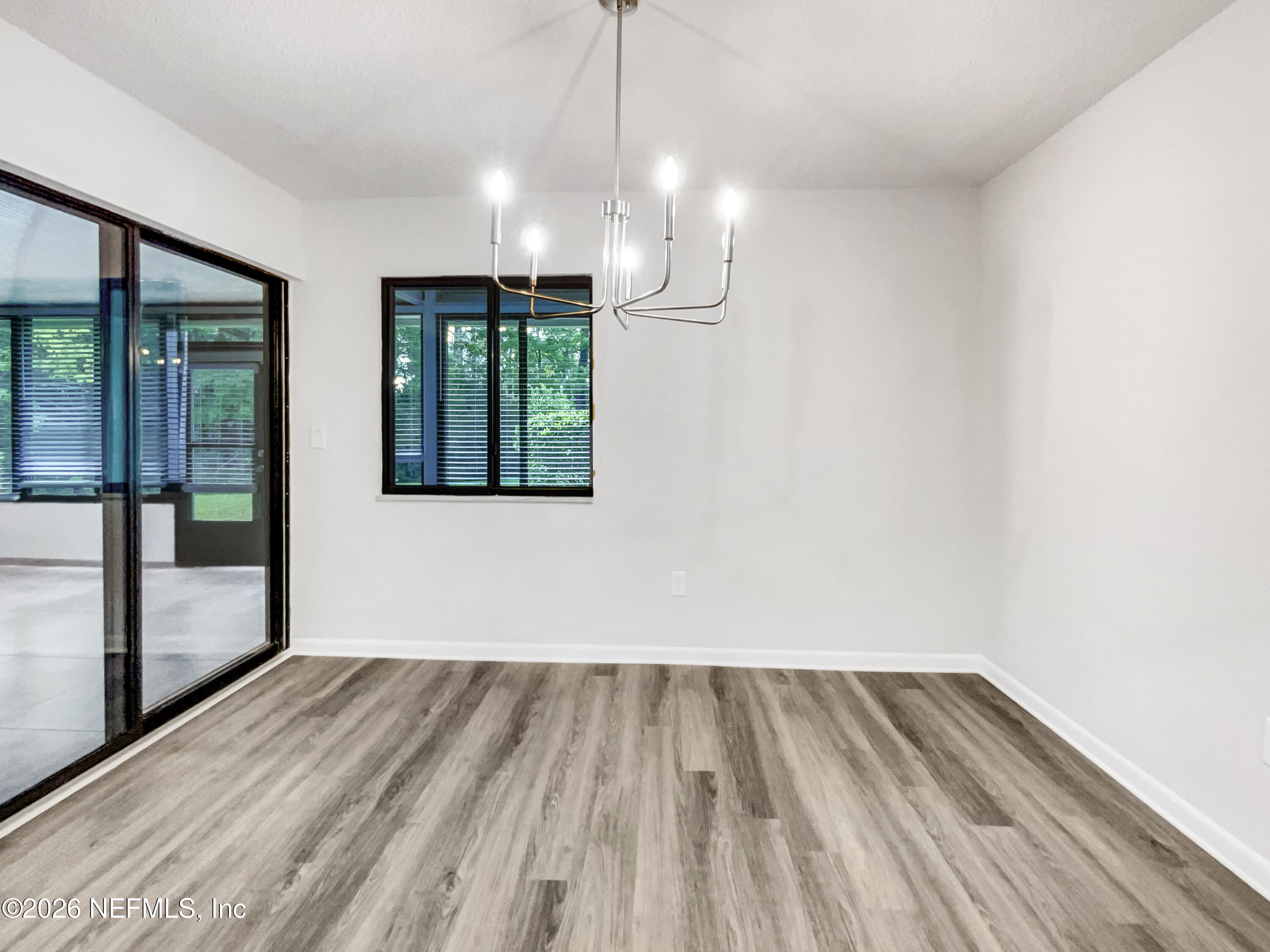7208 Cypress Cove Road, Unit 13 Jacksonville, FL 32244 - Photo 8 of 22 wooden floor in an empty room with a window