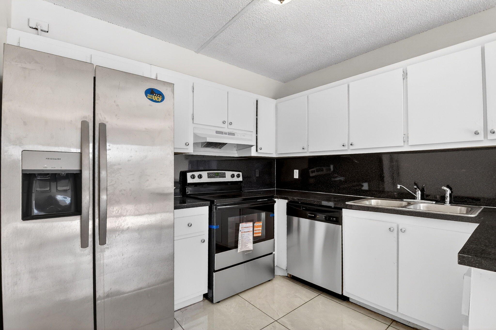 136 Woodland Road Palm Springs, FL 33461 - Photo 11 of 42 a kitchen with stainless steel appliances granite countertop a stove a refrigerator and a microwave