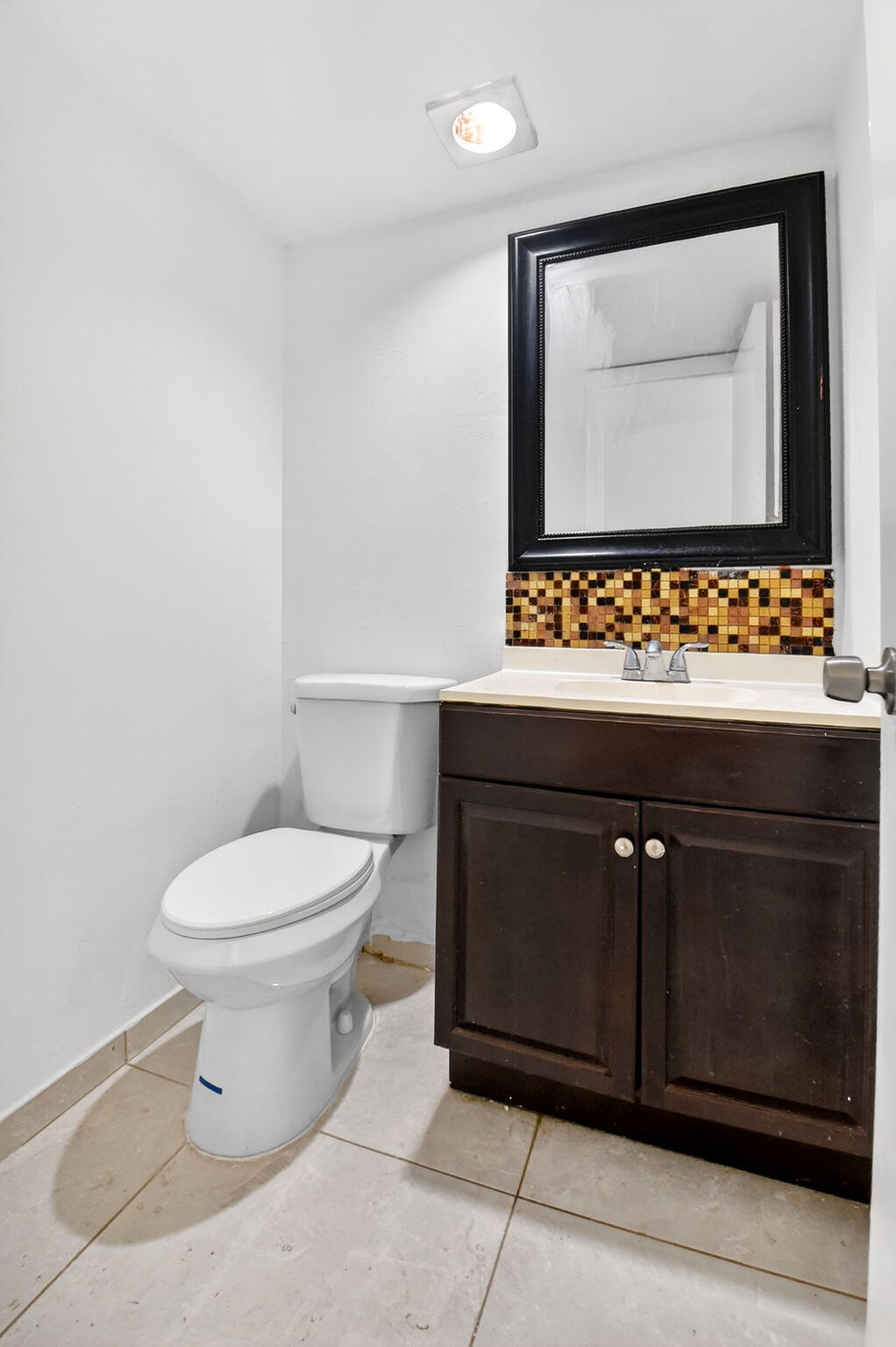 136 Woodland Road Palm Springs, FL 33461 - Photo 21 of 42 a bathroom with a toilet a sink and mirror