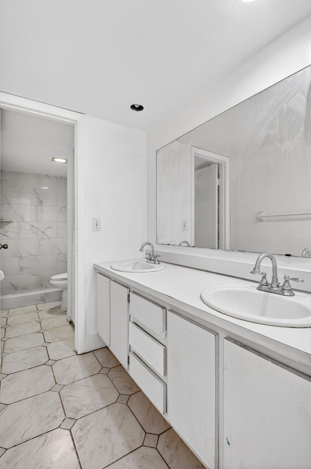 136 Woodland Road Palm Springs, FL 33461 - Photo 32 of 42 a spacious bathroom with a sink and a mirror