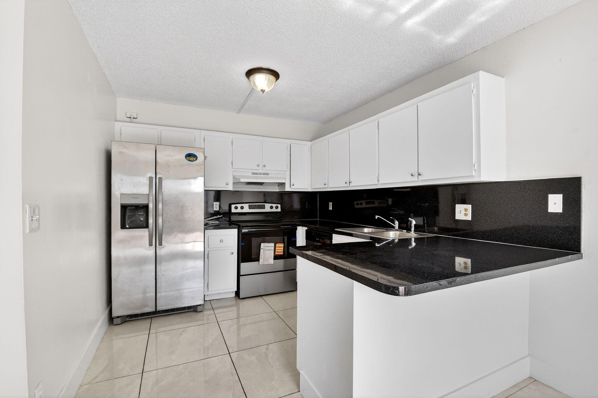 136 Woodland Road Palm Springs, FL 33461 - Photo 10 of 42 a kitchen with a refrigerator and a sink