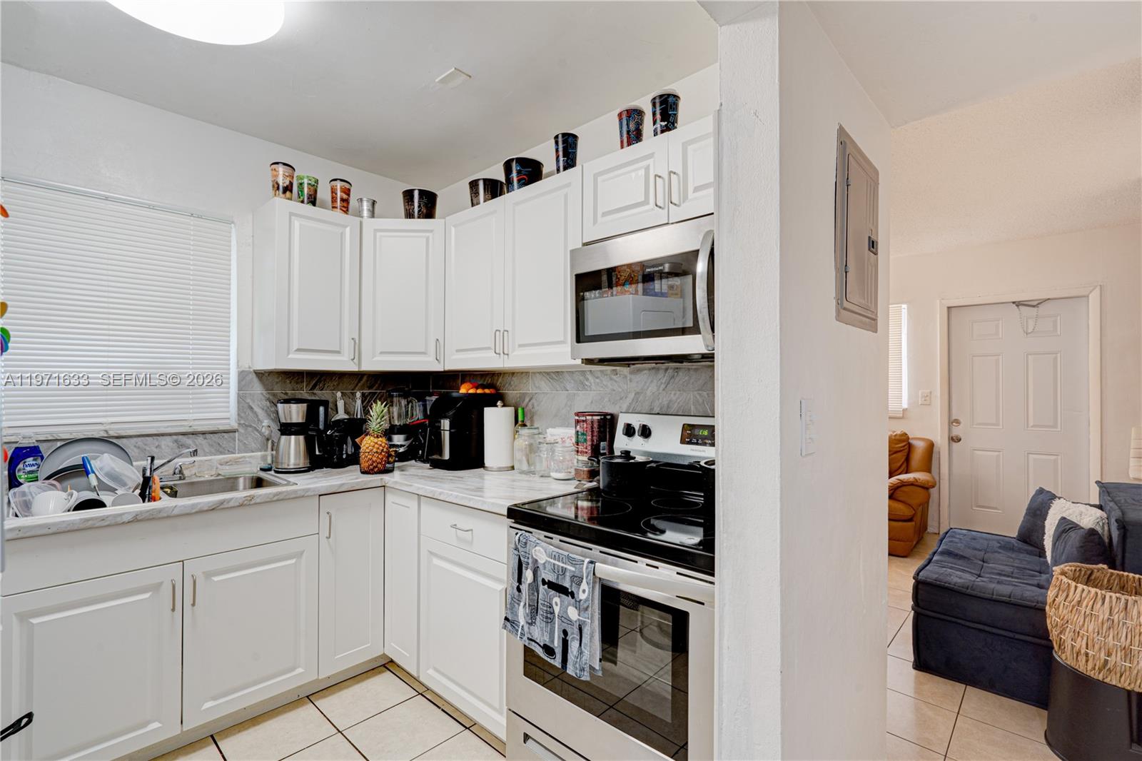 502-504 Phippen Waiters Road, Unit 4 Dania Beach, FL 33004 - Photo 8 of 16 a kitchen with stainless steel appliances granite countertop white cabinets sink and dishwasher a stove top oven with wooden floor
