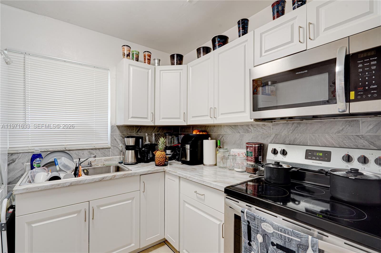 502-504 Phippen Waiters Road, Unit 4 Dania Beach, FL 33004 - Photo 9 of 16 a kitchen with stainless steel appliances granite countertop white cabinets sink and stove