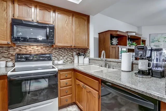a kitchen with granite countertop a stove sink and microwave