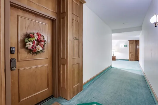 a view of a hallway to rooms and wooden floor