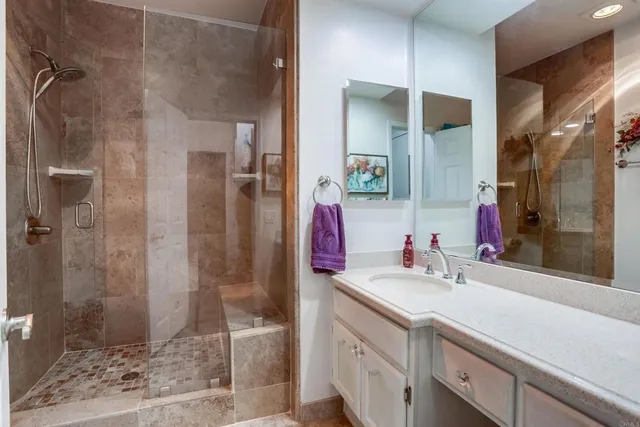 a bathroom with a double vanity sink mirror and shower