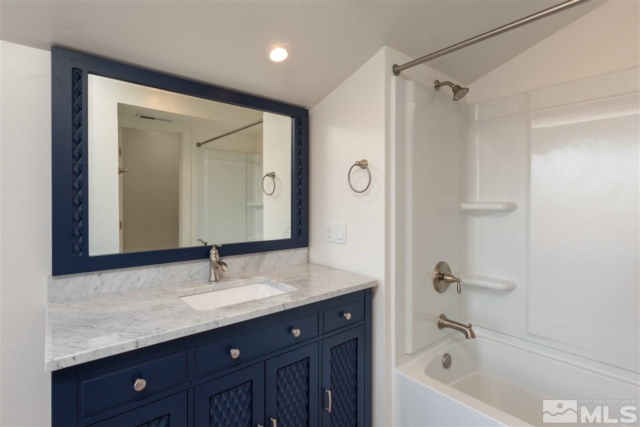 1969 South Villa Way Reno, NV 89509 - Photo 20 of 25 a bathroom with a granite countertop sink mirror and a bathtub