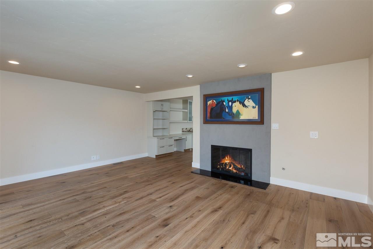 1969 South Villa Way Reno, NV 89509 - Photo 10 of 25 a view of an empty room with wooden floor fireplace and a window