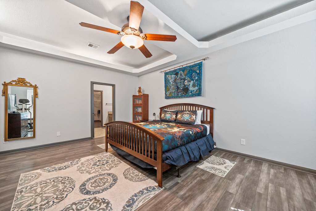 209 Lakeview Circle Spring Branch, TX 78070 - Photo 16 of 40 Bedroom with a tray ceiling, visible vents, baseboards, and wood finished floors