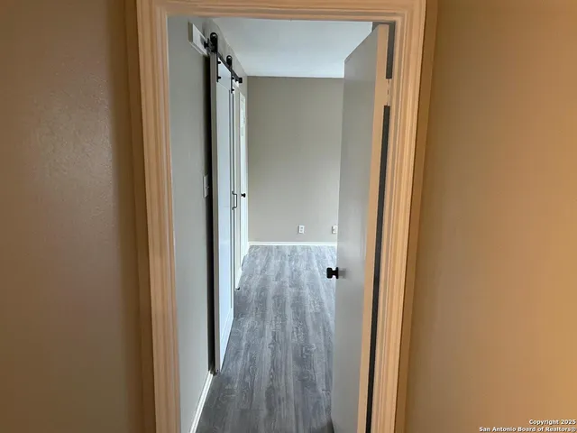 a view of a hallway with wooden floor