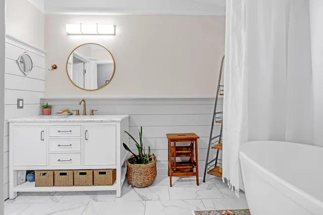 a bathroom with a tub sink and mirror