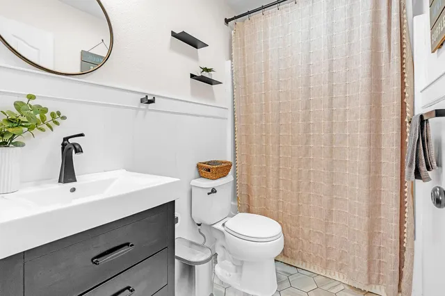 a bathroom with a sink a toilet and a mirror