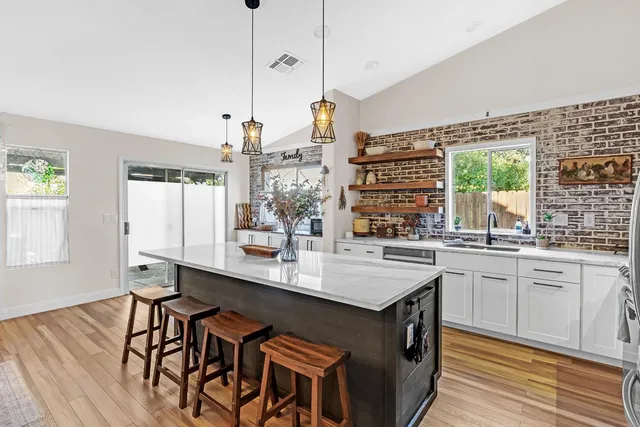 a kitchen with a sink stove and wooden floor