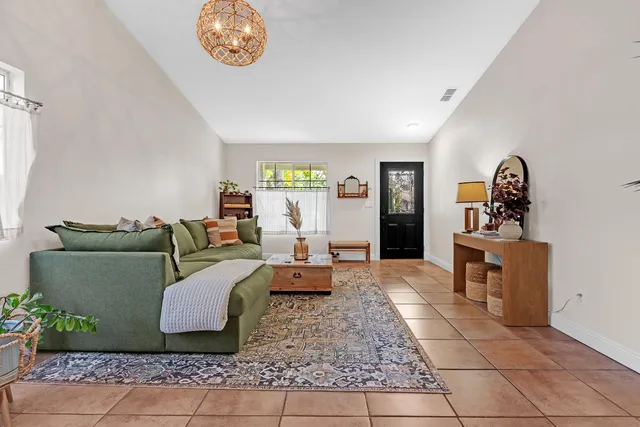 a living room with furniture a chandelier and a window